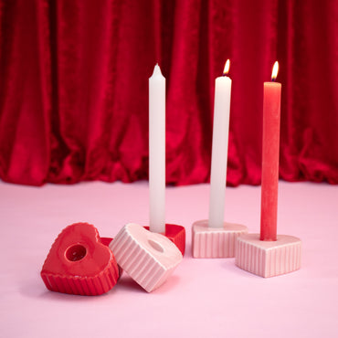suportes de velas vermelhos e rosa com formato de coração alguns com belas brancas e vermelhas a arder símbolo de romance para dia dos namorados