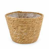 Cesto redondo para plantas em fibra natural, com forro interior em plástico, sobre fundo branco